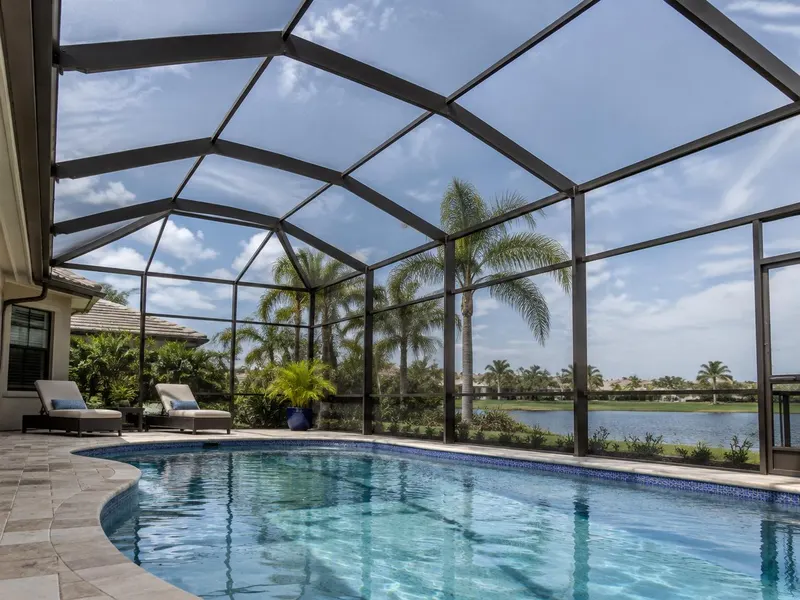 View from inside a swimming pool cage looking up at the frame and screen roof
